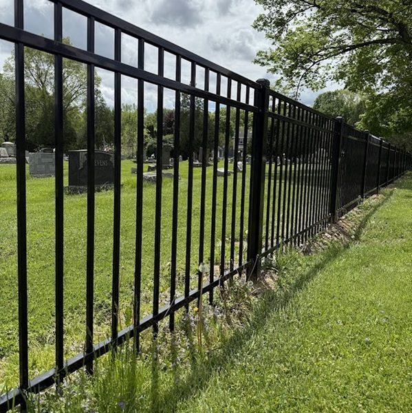 Black ornamental aluminum fence installed along a landscaped property line